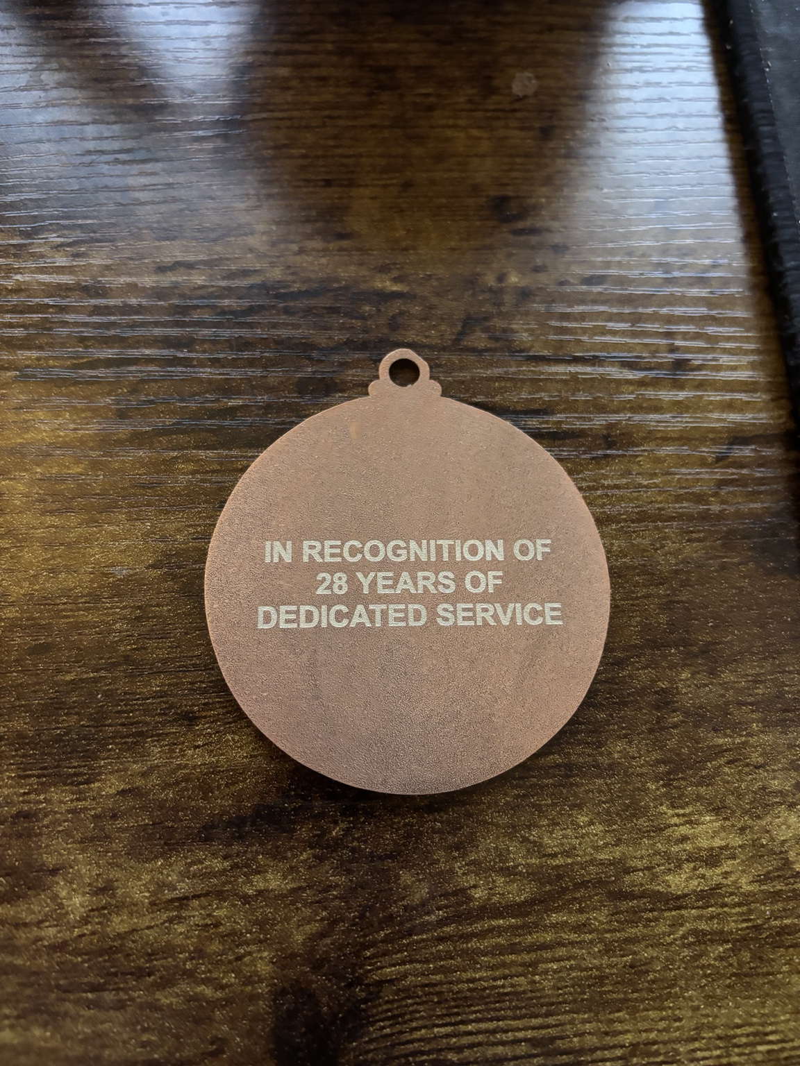 Reverse of the medal marked in recognition of 28 years of dedicated service
