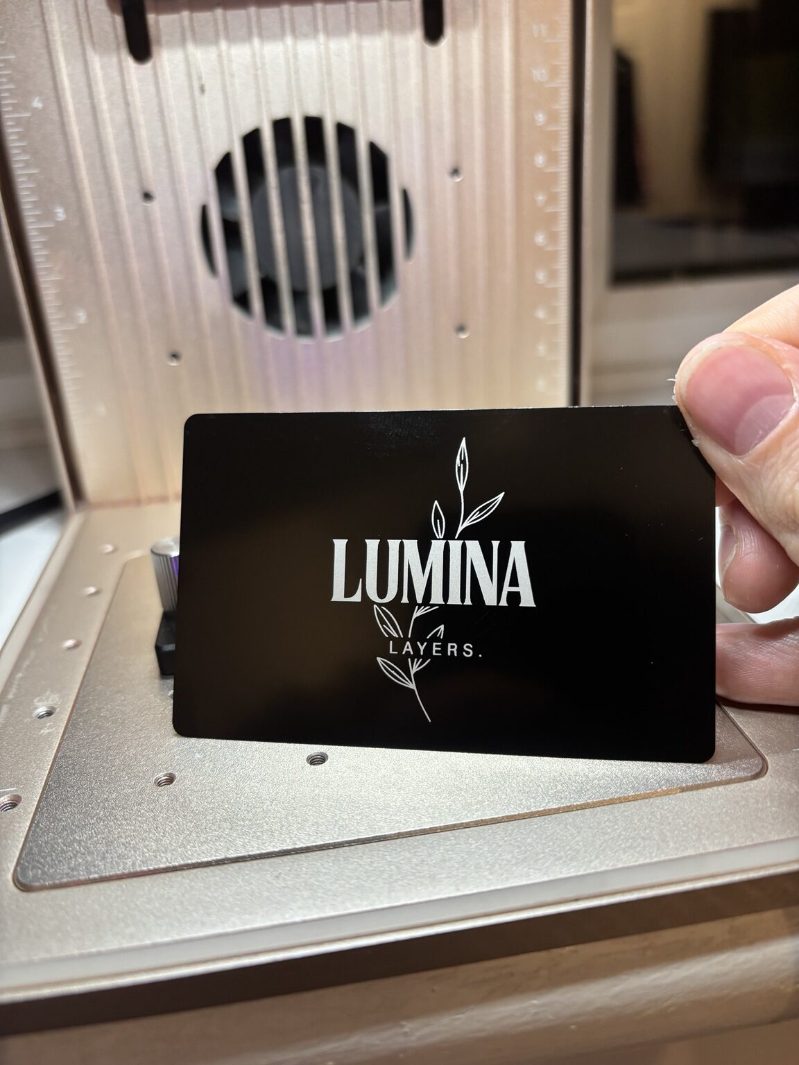 Lumina Layers logo engraved onto a black aluminium business card